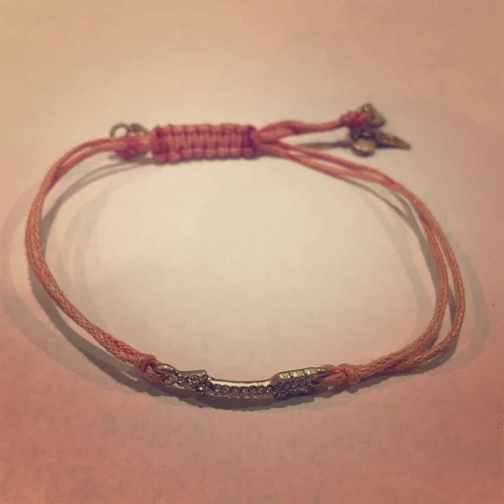 Adjustable string bracelet with embellished arrow